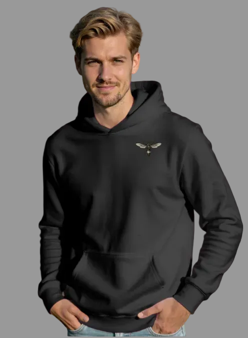 Man wearing a black hoodie with a logo in a field