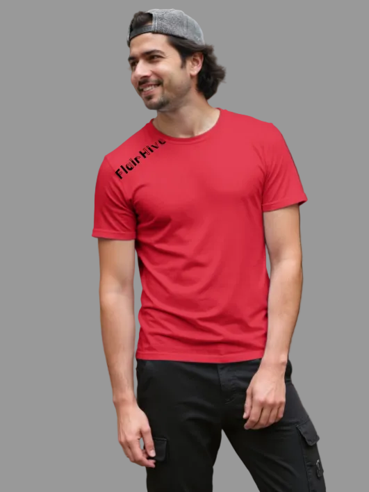 Man wearing a red t-shirt with text and black pants standing outdoors.