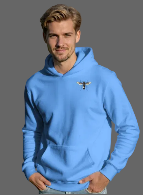 Man wearing a blue hoodie with a bee emblem in an outdoor setting